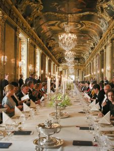 Photo convives à table dans salle chateau symbole rayonnement patrimoine culinaire de la france